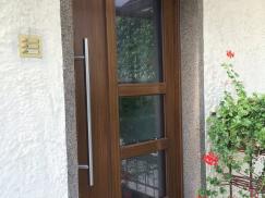 Holz-Haustür mit drei Lichtausschnitten und Klingel auf der linken Seite