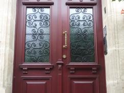 Haustür in rot mit Lichtausschnitt mit Verzierung und Seitenteil mit gleichem Lichtausschnitt 