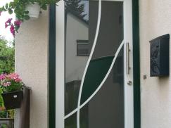 Haustür in weiß mit grünem Türrahmen und grünem Element 