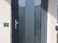 Haustür in grau mit großem Milchglas-Lichtausschnitt und grauem Ausschnitt 