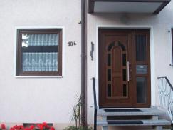 Holzhaustür mit acht im Rundbogen angeordneten Lichtausschnitten und Glas-Seitenteil mit Briefkastenschlitz 