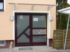 Holzhaustür mit drei großen Milchglas-Lichtausschnitten und Milchglas-Seitenteil mit Briefkasten- und Klingelanlage 