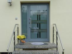 Haustür in grau mit großem Milchglas-Lichtausschnitt mit Muster und Milchglas-Seitenteil