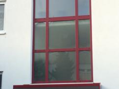 Fenster aus Milchglas mit rotem Rahmen und Haustür mit Milchglas und Milchglas-Seitenteil 