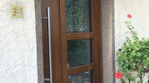 Holz-Haustür mit drei Lichtausschnitten und Klingel auf der linken Seite