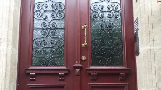 Haustür in rot mit Lichtausschnitt mit Verzierung und Seitenteil mit gleichem Lichtausschnitt