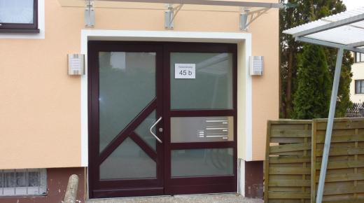 Holzhaustür mit drei großen Milchglas-Lichtausschnitten und Milchglas-Seitenteil mit Briefkasten- und Klingelanlage 