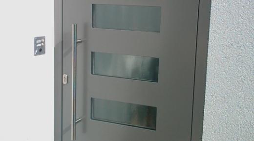 Haustür in grau mit fünf Milchglas-Lichtausschnitten und Klingel auf der linken Seite