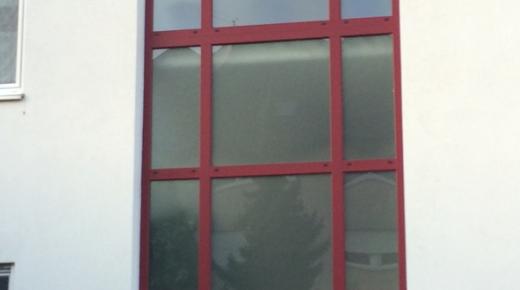 Fenster aus Milchglas mit rotem Rahmen und Haustür mit Milchglas und Milchglas-Seitenteil 