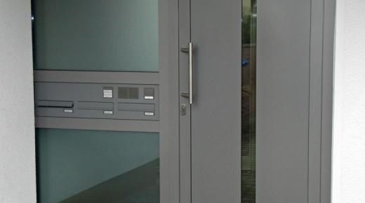 Haustür in grau mit Glas-Seitenteil mit Briefkasten- und Klingelanlage