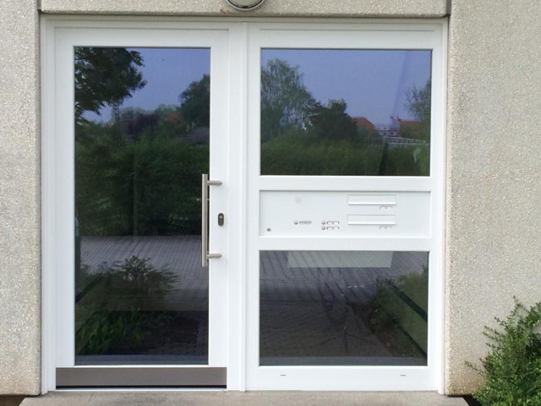 Glashaustür mit weißem Rahmen und breitem Seitenteil mit Briefkasten- und Klingelanlage 