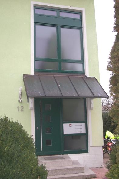 Haustür grün mit vier Lichtausschnitten und Glas-Seitenteil mit Anlage für Briefkästen und Klingeln 