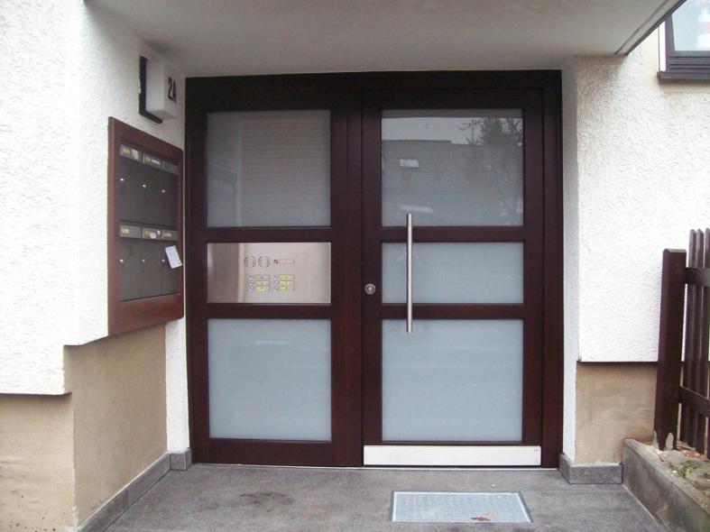 Holzhaustür mit drei Milchglas-Lichtausschnitten und Seitenteil mit Klingelanlage 
