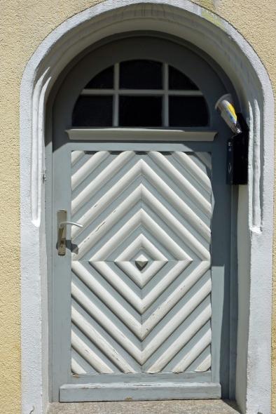 Haustür mit grauem Rahmen und weiß-grauem Muster