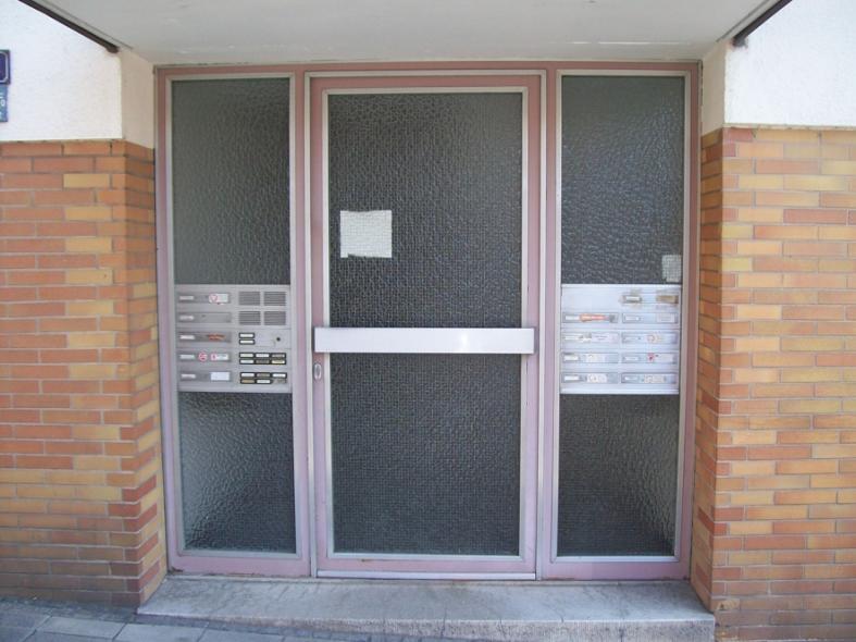 Haustür rosa mit zwei Seitenteilen mit jeweils Briefkasten- und Klingelanlage 