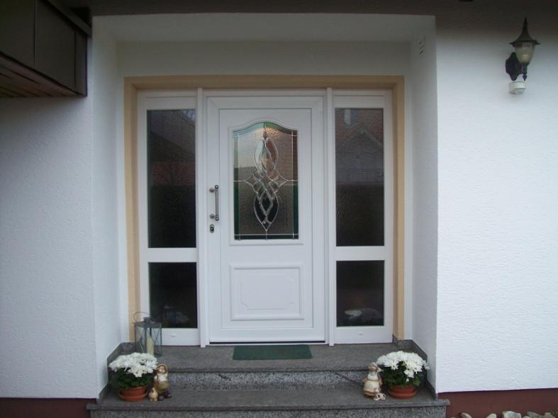 Haustür in weiß mit Lichtausschnitt mit Verzierung und zwei Seitenteilen mit jeweils zwei Lichtausschnitten 