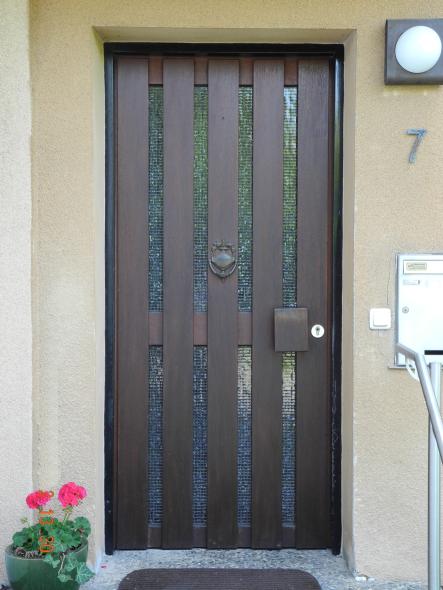 Holzhaustür mit acht schmalen und vertikal angeordneten Lichtausschnitten und Klopfring