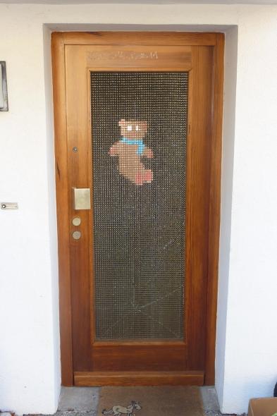 Wohnungseingangstür aus Holz mit beschädigtem Lichtfenster