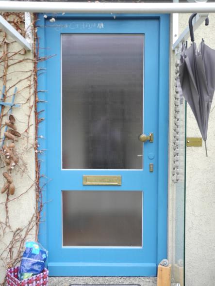 Haustür in blau mit zwei Lichtausschnitten und Briefkastenschlitz 