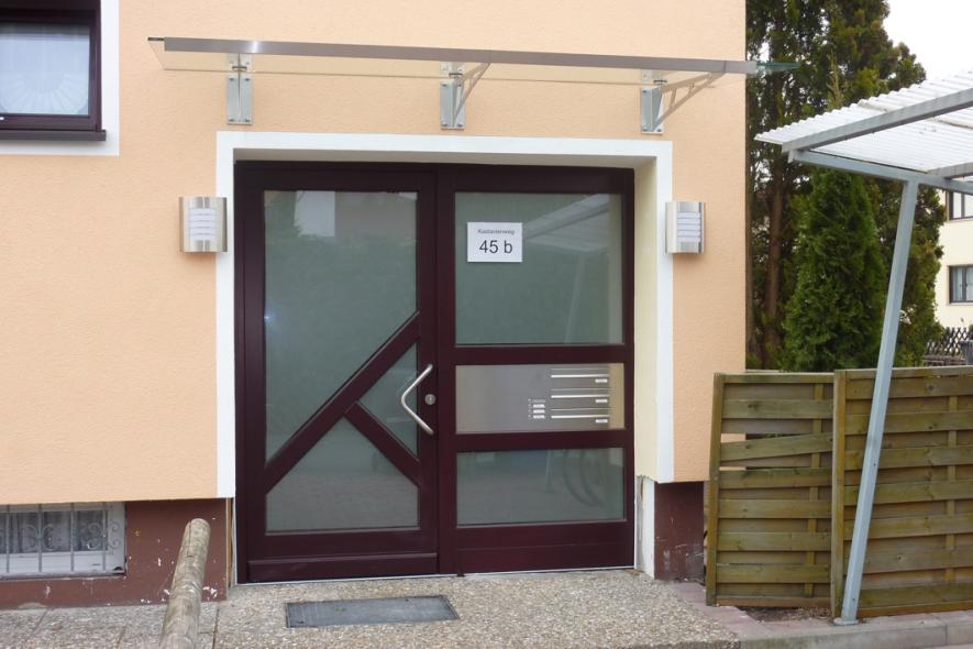 Holzhaustür mit drei großen Milchglas-Lichtausschnitten und Milchglas-Seitenteil mit Briefkasten- und Klingelanlage 