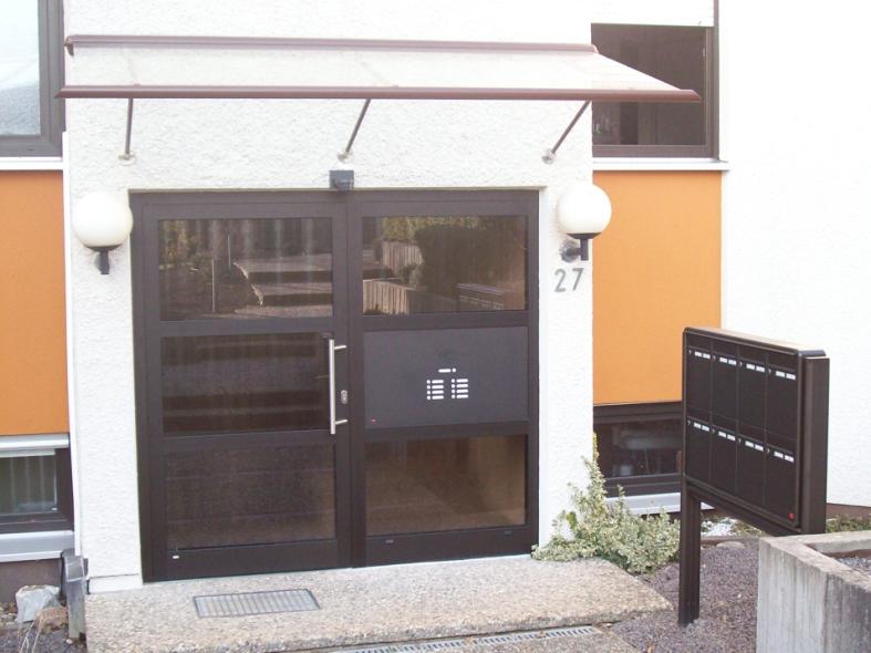 Holzhaustür mit drei Lichtausschnitten und Glas-Seitenteil bei Mehrfamilienhaus