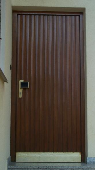 Alte Holz-Haustür mit vertikalen Dielen und gold-schwarzem Türgriff 